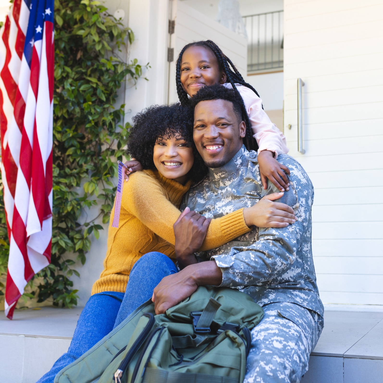 Military family smiling on home porch