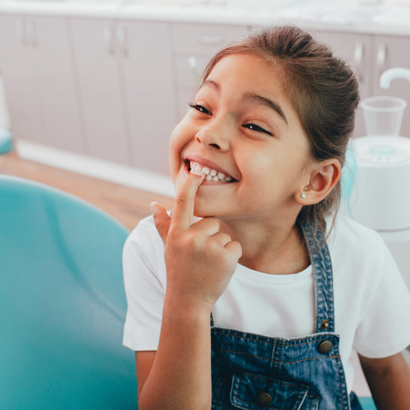 Smiling girl in pediatric dental office, showcasing a healthy smile and engaging with dental care, reflecting a friendly atmosphere at Pediatric Dental Partners in Shreveport.