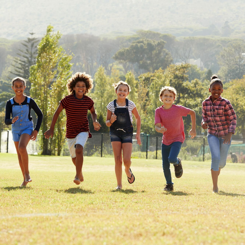 Kids running together outdoors, happy patients of our pediatric dentists in Shreveport LA and Bossier City